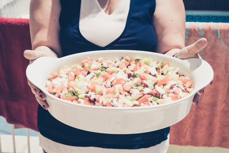 Close-up of unrecognizable woman holding bowl full of healthy vegetable saladの写真素材