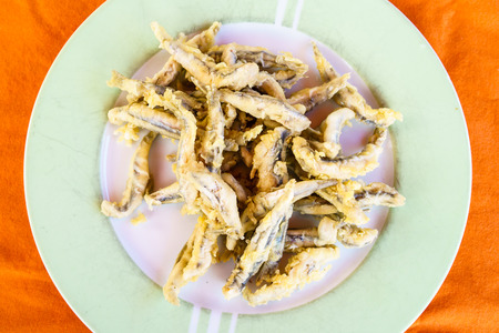 Close-up of fried fish on white plate in daylight.From aboveの写真素材
