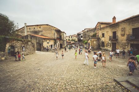 SANTILLANA DEL MAR,CANTABRIA,SPAIN - 31 AUGUST,2016:Crowd of people walking on paved square of old cityのeditorial素材