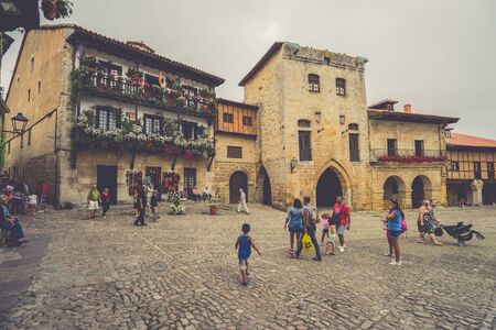 SANTILLANA DEL MAR,CANTABRIA,SPAIN - 31 AUGUST,2016:Crowd of people walking on paved square of old cityのeditorial素材