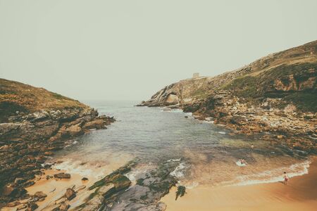 SANTA JUSTA BEACH,CANTABRIA,SPAIN - 31 AUGUST,2016: View of idyllic bay at rocky land with tourists swimming in waterのeditorial素材