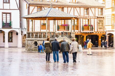 Ezcaray, La Rioja, Spain - 13.11.2016: Tourists standing on square and looking at old buildings.のeditorial素材