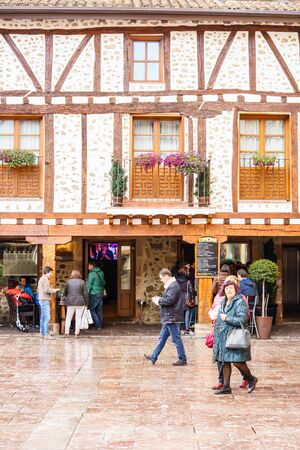 Ezcaray, La Rioja, Spain - 13.11.2016: Tourists standing on square and looking at old buildings.のeditorial素材