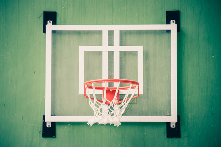 Front view of basketball hoop on green wall in gymnasium.の写真素材