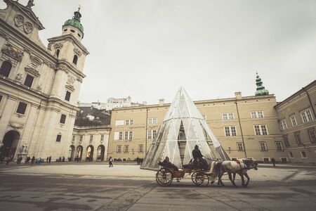 SALZBURG, AUSTRIA - MARCH 12: View on ancient Salzburg square with cathedral and carriage with...