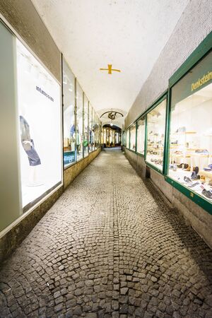 SALZBURG,AUSTRIA - 11 MARCH 2016: Back view of tourists walking along european street with different shops in Salzburg, Austriaのeditorial素材