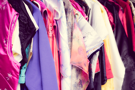 Close up of bright colourful female's clothing on hangers.の写真素材
