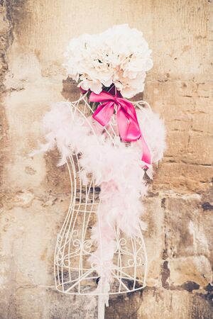 The mannequin with white decoration placed near old stucco wall.の写真素材