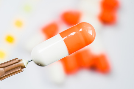 Horizontal shot of the pill placed on a pin of a syringe.の写真素材