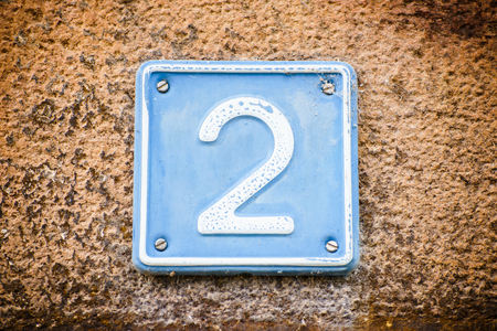 Close up shot of plate with number two on wall of building .の写真素材