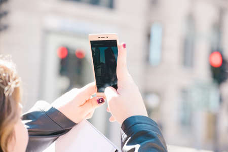 A person shooting skyscraper at her smartphone camera in Boston, USA.の写真素材