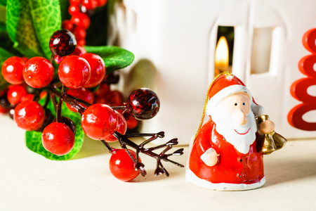 Close up of Christmas decorations and figurine of Santa Claus with bells standing on wooden surface. の写真素材