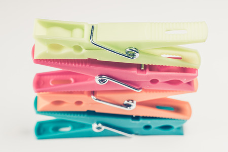 Four colorful clothes pins on white surface. の写真素材
