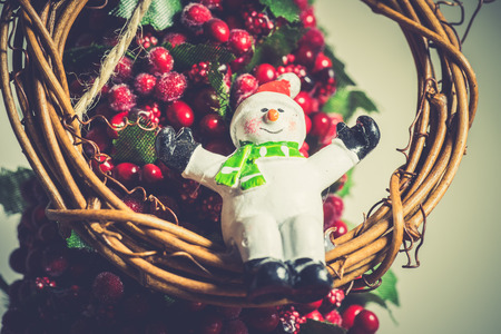Close up of festive snowman and twig wreath and other Christmas decorations. の写真素材