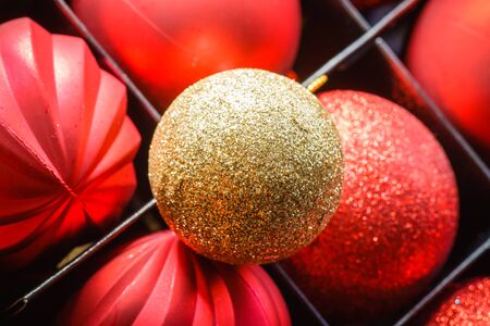 Close up of red and golden glittery baubles in box. の写真素材