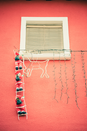 Santa figurines hanging on the ladder near the deer. Vertical indoors shot. の写真素材