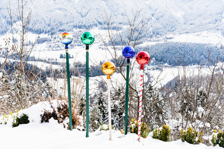 Decorative colorful balls on bars in snow against of winter landscapeの写真素材