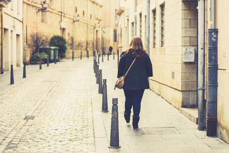 Back view of a female walking in a street of Logrono, Spain. の写真素材