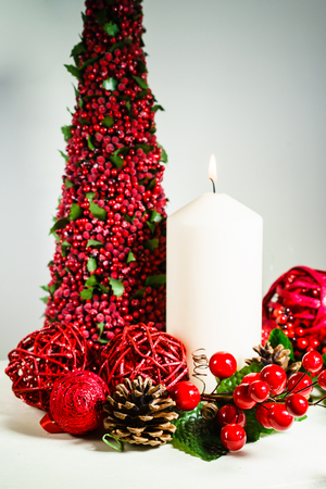 Close up Christmas composition of burning candle surrounded with decorative things and pine cones. の写真素材