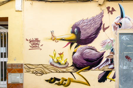 MALAGA,SPAIN - 28 MAY 2016: Graffiti of mother bird with worm above nest with baby birds. UPHO Festival.のeditorial素材