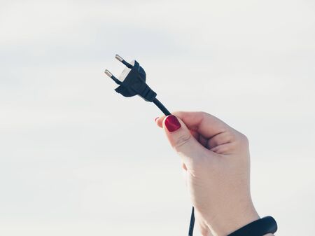Woman holding a black plugの写真素材