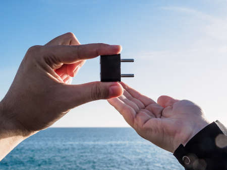 Man holding a black plug