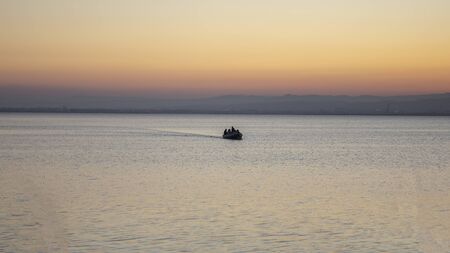 Boat with people in Albufera of Valencia at sunset, Valencia, Spain.