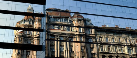 Panoramic architecture contrast Old house reflection in glass windows of a new modern building in Budapest, Hungaryのeditorial素材