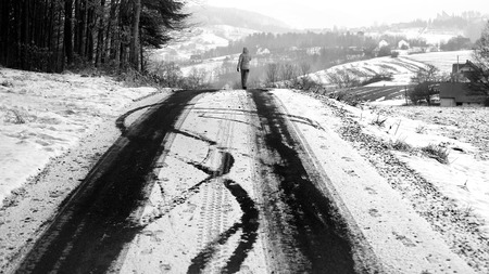 Person walking on the snowy road. - Black and Whiteの写真素材