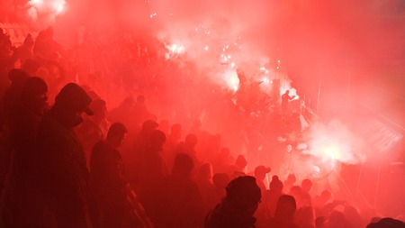 KRAKOW, POLAND-DECEMBER 13, 2017: Polish soccer fans lighting smoke flares at Cracovia Stadium,...