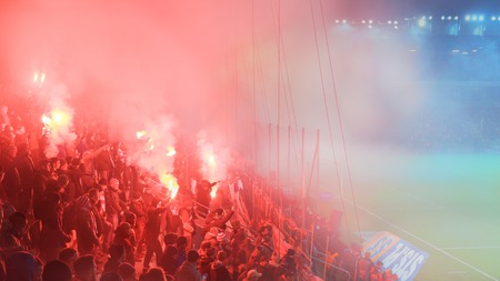 KRAKOW, POLAND-DECEMBER 13, 2017: Polish soccer fans lighting smoke flares at Cracovia Stadium,...