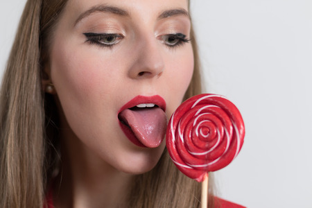 Young woman close up of her mouth licking a lollipopの写真素材