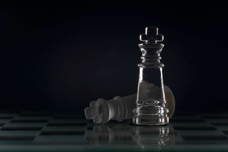 Fallen chess king as a metaphor for fall from power black background copy space