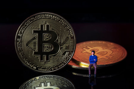 Miniature people : Man sitting on Bitcoin digital money crypto currency concept.