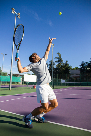 Professional tennis player is doing to kick tennis on a tennis court on a sunny summer morning.の写真素材