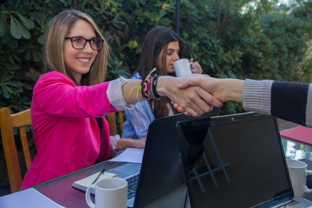 Young businesswomen shaking hands. They are Greeted Before They start working together.の写真素材