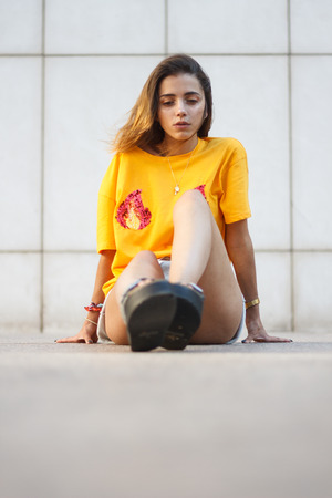 Young attractive sensual woman sitting on floor in the street.の写真素材