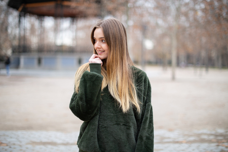 Portrait of happy smiling young blond woman in a park in autumnの写真素材
