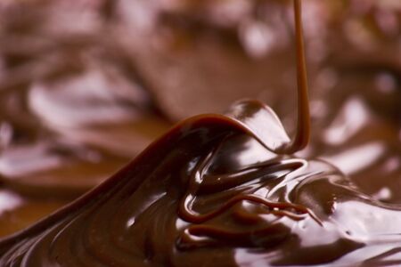 Macro of liquid chocolate making irresistible waves.の写真素材