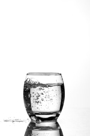 A black and white photo of a glass with water which is making bubbles.
の写真素材