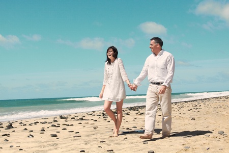 couple walking and laughing along the beachの写真素材