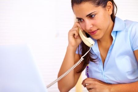 Portrait of a cute young business woman talking on phone.の写真素材