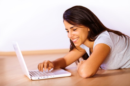 Portrait of a cute young woman using a laptop.の写真素材