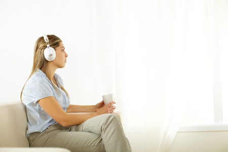 Portrait of a young cute woman listening to quiet music の写真素材