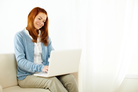 Portrait of a beautiful young woman resting on laptop at homeの写真素材