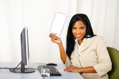 Portrait of a beautiful young business lady at work showing a letter to you and smilingの写真素材