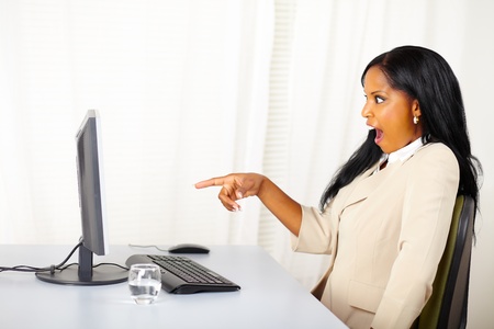 Portrait of a surprised business lady pointing the computer screenの写真素材