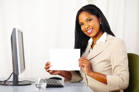 Portrait of a young executive woman at work while show a white cardの写真素材