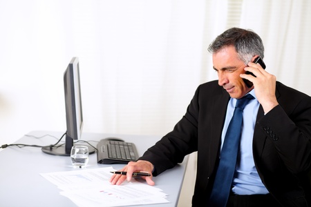 Potrait of a attractive businessman speaking on mobile at the officeの写真素材