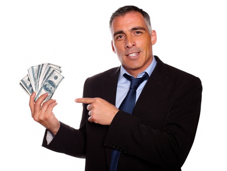 Portrait of a hispanic senior business man holding and pointing  cash dollars on isolated backgroundの写真素材
